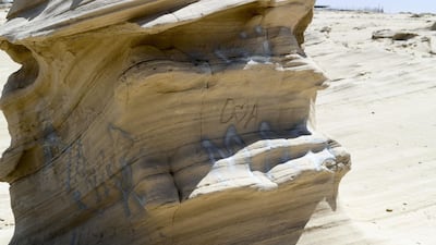 Graffiti vandalism near the entrance of the ancient rock formations attraction in the outskirts desert area, at Al Wathba. Khushnum Bhandari / The National