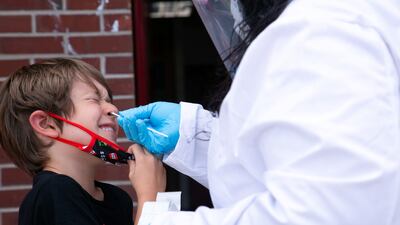 Nurse Alisa Ellis-Balogun tests 7-year-old Thomas Byrd for coronavirus at Seneca High School a day before returning to school in Louisville, Kentucky, US, on August 10, 2021. Reuters