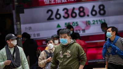 Pedestrians walk past an electronic billboard showing the Hang Seng Index figures in Hong Kong, China on February 3. EPA