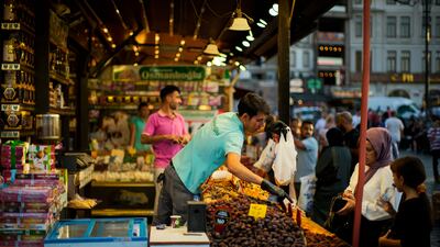 A merchant talks to a customer at the Egyptian spices market in Istanbul. Turkey's central bank on Thursday lowered its key interest rate despite inflation surging to nearly 80 per cent. AP