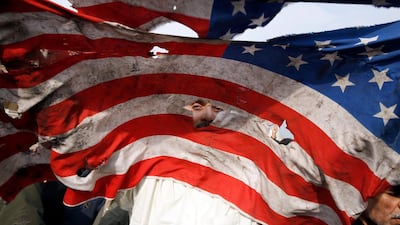 A US flag is defaced during an anti-US demonstration to condemn the killing of Suleimani after Friday prayers in Tehran. EPA