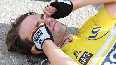German rider Maximilian Schachmann lies on the floor exhausted after winning the shortened Paris - Nice race. AFP
