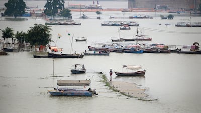 A boatman walks on a flooded road near Sangam, the confluence of the Ganges, Yamuna and mythical Saraswati rivers, as the river water levels rise in Allahabad. AFP