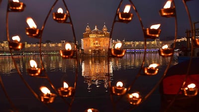 Lamps lit by devotees shine in front of the illuminated Golden Temple, the holiest of Sikh shrines, on the birth anniversary of Guru Nanak in Amritsar, India. AP Photo