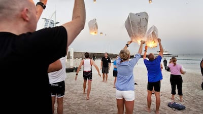 Members of the TriDubai group send lanterns floating into the sky above Jumeirah beach in Dubai yesterday before taking part in a special swim in memory of Roy Nasr, the 49-year-old Lebanese triathlete who was run over and killed by a drunk driver while cycling with two friends near Safa Park three weeks ago. Antonie Robertson / The National