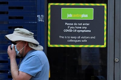 A person wearing a protective face mask walks past a Job Centre Plus office, amidst the outbreak the coronavirus in London, Britain, August 11, 2020. REUTERS