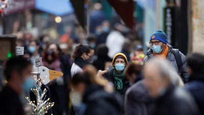 People, wearing protective face masks, walk on the Mouffetard street, amid the spread of the coronavirus disease (Covid-19) pandemic, in Paris, France, December 30, 2021. Reuters