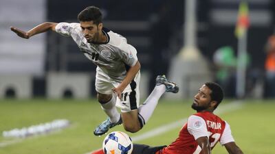 Al Sadd's Hassan Al Haidos, gets tripped up by Al Ahli's Abdul Aziz Sanqour during their Asian Champions League Group D match at the Jassim bin Hamad Stadium in Doha on April 22, 2014. It was Ahli that was upended as Sadd's 2-1 ended the Arabian Gulf League club's ACL adventure. Karim Jaafar / AFP