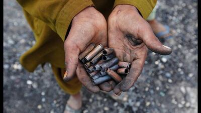 A boy displays bullet casings collected near tankers of a NATO supply convoy which were attacked a day earlier in Hub, Pakistan. Akhtar Soomro / Reuters