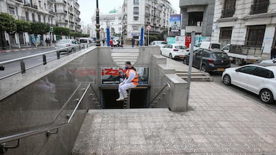 A cleaning worker wearing a protective suit sits in the entrance of metro station in Algiers, Algeria. Reuters