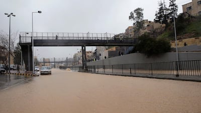 People cross a pedestrian bridge over a flooded street during heavy rains in Amman, Jordan. Reuters