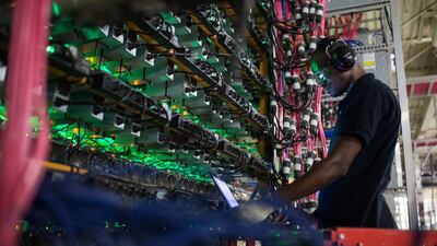 A technician monitors cryptocurrency mining rigs at a Bitfarms facility in Quebec, Canada. Bloomberg