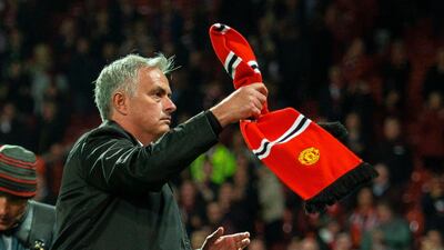 Jose Mourinho holds up a Manchester United scarf thrown from the crowd after the 3-0 defeat to Tottenham at Old Trafford. EPA