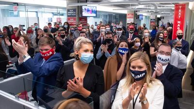 Campaign workers applaud as President Donald Trump visits his campaign headquarters in Arlington. AFP