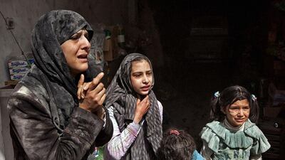 Survivors of an air strike by government forces, that according to eyewitnesses destroyed two five-storey apartment blocks and severely damaged several buildings, look in shock at the scene of the attack as local residents try to rescue those trapped under the rubble in a residential neighbourhood in Aleppo, Syria. Victor Breiner / AFP