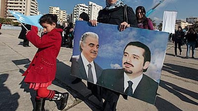 A supporter of former Lebanese prime minister Saad Hariri’s Mustaqbal movement holds a poster of Mr Hariri and his late father, Rafik Hariri, during the rally in Tripoli, Lebanon, yesterday. Thousands of Hariri supporters attended the rally.