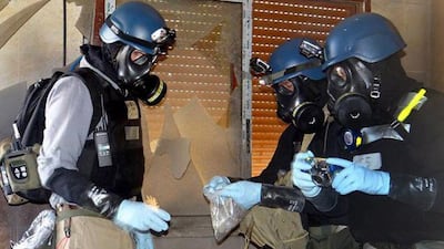 Members of the UN investigation team take samples from the ground in the Damascus countryside of Zamalka, Syria. AP Photo/Local Committee of Arbeen