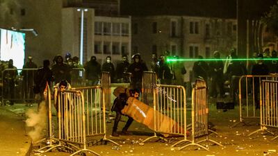 Protesters blockade the street as they throw stones at riot police during clashes in central Beirut. EPA