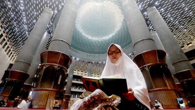 A woman reads the Quran as she waits for iftar at Istiqlal Mosque in Jakarta, Indonesia. EPA