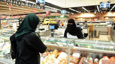 An employee serves a customer at the hypermarket. AFP