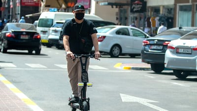 An e-scooter rider heads into oncoming traffic on Hamdan Steet, central Abu Dhabi. Victor Besa / The National