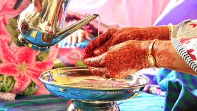 Once everyone is seated, one serving member walks with water in a chelamchi lota (a kind of basin and jug) for everyone to wash their hands. Subhash Sharma for The National