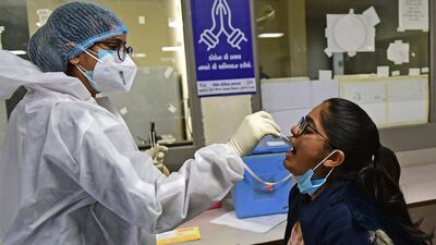 A health worker takes a swab sample from a girl at a hospital in Ahmedabad on December 27, 2022. AFP
