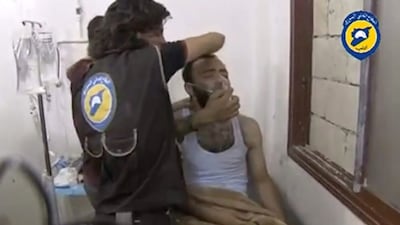 A video said to be taken on August 1, 2016, shows two men standing over another man on a bed, forcing him to sit up as he breathes through a mask in the town of Saraqeb, Idlib province. Social Media/Handout via Reuters