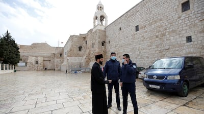 Palestinian police officers stand guard outside the Church of the Nativity that was closed as a preventive measure against the coronavirus. Reuters