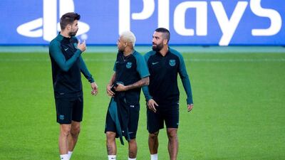 Barcelona players, left to right, Gerard Pique, Neymar, and Arda Turan attend their team’s training session. Marius Becker / EPA