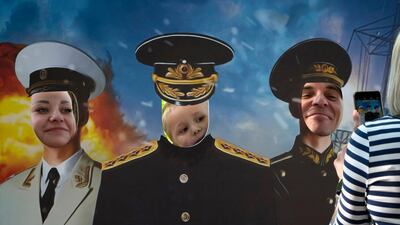 A family poses with their faces showing through a cardboard cutout depicting Russian Navy officers during the Navy Day celebration in St.Petersburg, Russia. AP Photo