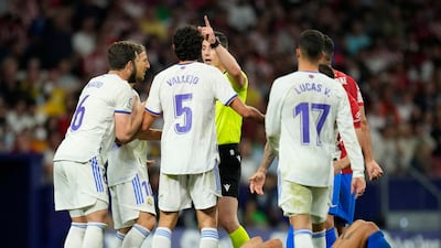 Atletico Madrid's Yannick Carrasco lies on the pitch in pain as Real Madrid players argue with referee Cesar Soto Grado. AP Photo