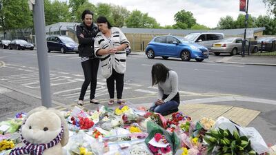 A woman reacts after leaving flowers outside Royal Artillery Barracks, Woolwich Headquarters, close to the scene where a soldier was murdered in John Wilson Street, Woolwich, south east London, on May 23, 2013. Facundo Arrizabalaga / EPA