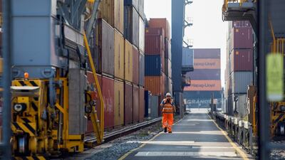 An employee passes between shipping containers on the dockside at London Gateway port, operated by DP World, in Stanford-le-Hope. Getty Images