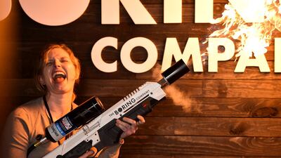 An attendee operates a Boring Company flamethrower at the company's photo booth. Reuters
