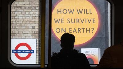 A sign advertising a book titled "How Will We Survive On Earth?" is seen on an underground station platform in London, England. Getty