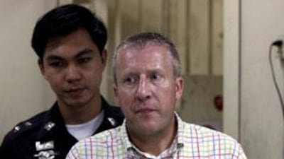Michael Bryan Smith, in handcuffs in Bangkok, faces extradition to the UAE.