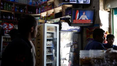Yemenis watch the Houthi military spokesman Yahya Sarea on a TV screen delivering a statement about alleged rebel attacks on Saudi and Emirati cities. EPA
