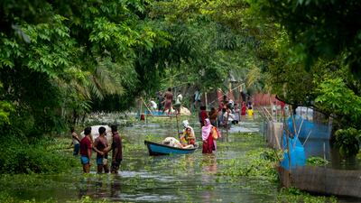People leave the submerged village of Tarabari in the north-eastern Indian state of Assam and head for higher ground to escape rising floodwater. AP