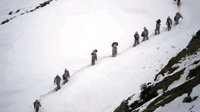 Pakistani army soldiers carry supplies up the 2,400 metre mountain near their outpost, Kalpani Base, in Pakistan's Dir district. Yesterday, an avalanche smashed into their base on a Himalayan glacier close to India.