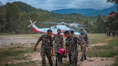 Soldiers carry a wounded resident taken by helicopter to a military camp, after flash floods in Trishuli, Nepal. Getty Images