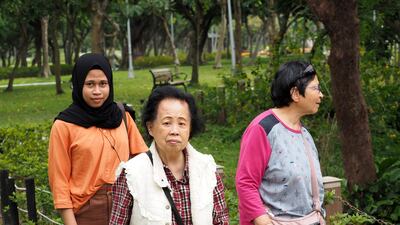 A migrant worker (L) in a park in Taipei, Taiwan, 18 March 2020. EPA
