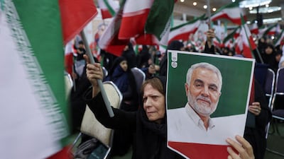 An Iranian woman holds a picture of Qassem Suleimani. The IRGC commander was assassinated during US President Donald Trump's first administration on January 3, 2020. Reuters
