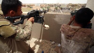 Pro-government forces stand guard at a rooftop look out point.