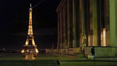 A woman walks her dog on the empty Trocadero, near the Eiffel Tower, during a curfew. AP
