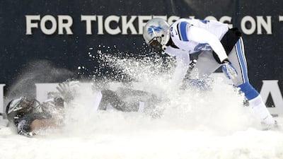 Philadelphia's Riley Cooper, left, falls into the snow next to Detroit's Chris Houston on Sunday. Matt Rourke / AP