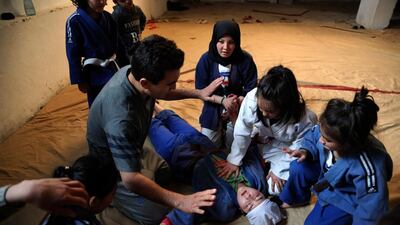 Jiu Jits coach Sayed Jawad Hussain helps Rana Rasuli after she fainted during a training session in Kabul. AP