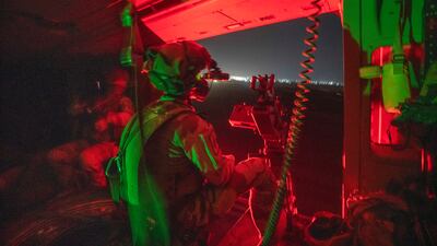 A French Barkhane force soldier mans a machine gun on board a Caiman transport helicopter during a night mission in Gao, Mali. AP Photo