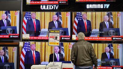 An Israeli man watches the televised press conference of US President Donald Trump and Israeli Prime Minister Benjamin Netanyahu at an electronics shop in the Israeli city of Modiin on January 28, 2020. Palestinians staged protests against US President Donald Trump's Middle East peace plan, hours before it was to be unveiled in Washington. Thousands demonstrated in Gaza, burning pictures of Trump and the American flag, while further rallies were planned for the coming days. / AFP / GIL COHEN-MAGEN