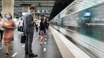 Morning commuters wearing wait to board a train at the underground metro railway station in the La Defense business district in Paris. Bloomberg